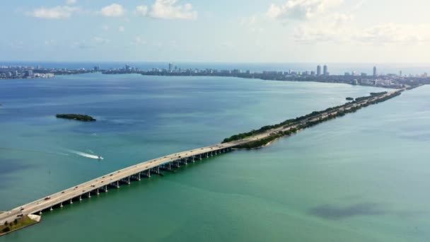 4Kドローン映像 ビスケインベイマイアミビーチの方向に橋の空中ビュー 晴れた春のフロリダ ヨットは青い水に浮かんでいる アメリカの観光事業のための美しい背景 — ストック動画