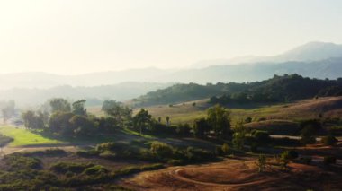 Kaliforniya 'daki güzel bir dağ manzarasının 4k drone görüntüsü. Günbatımı ışığı Ventura County 'deki bir doğa koruma alanının tepelerine düşüyor. Ojai Vadisi. Casitas Gölü kıyısında. ABD