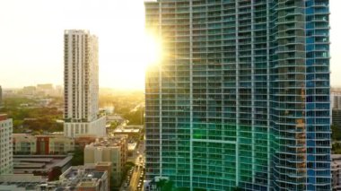 4K sinematik hava görüntüsü, modern şehir manzarası, insansız hava aracı görüntüleri. Altın bir günbatımı güneşinin zemininde cam ve betondan yapılmış konutların tasarımı. Miami şehrinin modern mimarisi