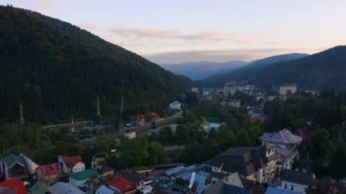 Romanya 'nın Carpathian dağlarındaki küçük Sinaia kasabasındaki sinematik 4K görüntüler, evler ve demiryolu manzarası. Yumuşak günbatımı ışığında güzel yeşil orman. Renkli Avrupa manzarası