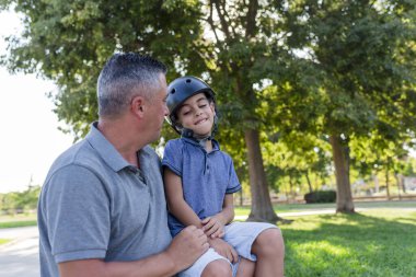 Father and son spending time together outdoors in a park. Family concept.