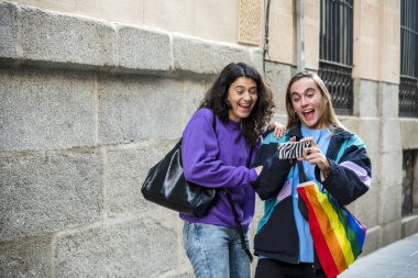 Two friends taking a selfie while walking outdoors. Friendship and LGBT concept.