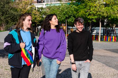 Young diverse friends walking on the street with the lgbt rainbow flag. Lgbt concept.