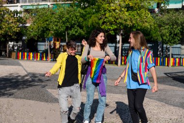 Igbt gökkuşağı bayrağıyla sokaklarda yürüyen farklı genç arkadaşlar. Lgbt kavramı.