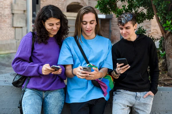 stock image Friends using mobile phone while standing outdoors on the street. Lgbtq, friendship and technology concept.