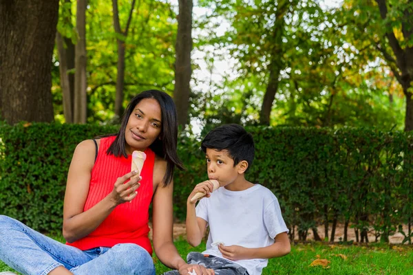 stock image Mother and son enjoying eating ice-cream together outdoors in a park. Family, food and summer concept.