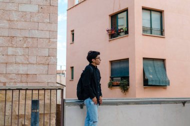 Kentin dar sokaklarında poz veren kendinden emin genç bir transseksüelin görüntüsü..