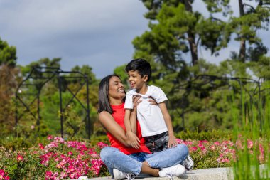 Anne ve oğlu parkta bir günün tadını çıkarırken birlikte eğleniyorlar. Aile kavramı.