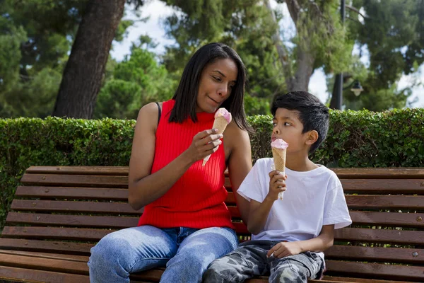 stock image Mother and son enjoying eating ice-cream together outdoors in a park. Family, food and summer concept.