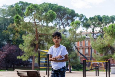 Genç bir çocuk parkta oynuyor ve eğleniyor. Çocukluk kavramı.