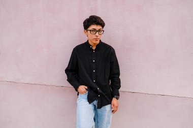 Sokakta poz verirken duvara yaslanan gözlüklü genç bir transseksüel..