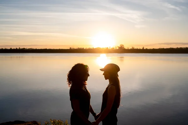 Pareja Lesbianas Mirándose Abrazándose Mientras Están Pie Junto Lago Atardecer —  Fotos de Stock