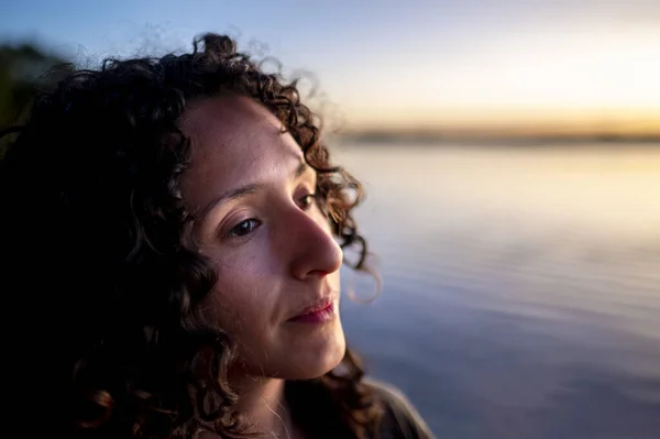 stock image Close-up of a mixed-race thoughtful woman outdoors at sunset.