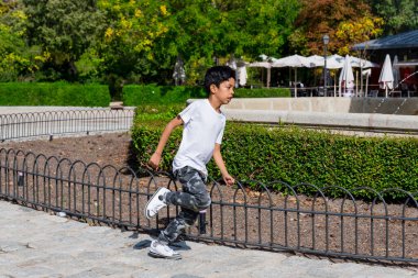 Genç bir çocuk parkta çocuk parkında koşarken eğleniyor. Çocukluk kavramı.