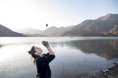 Doğanın tadını çıkarırken ellerine ve yüzüne çamur bulaştıran bir kadın. Doğa konsepti.