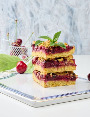 Kare dilimler halinde kiraz parçacıkları beyaz bir tahtanın üzerinde duruyor, yaz tatlısı.