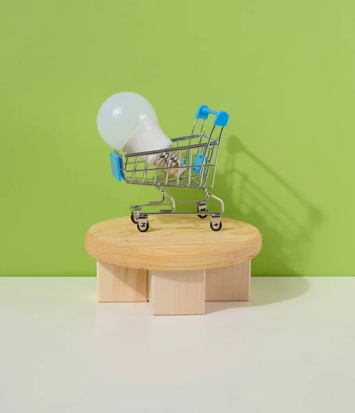 Miniaturowy Wózek Żelaza Szklana Biała Lampa Zielonym Tle Kupno Sprzedaż — Zdjęcie stockowe