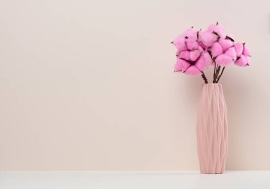 Beyaz masa üzerinde gül rengi pamuk buketli pembe seramik vazo, boşluğu kopyala