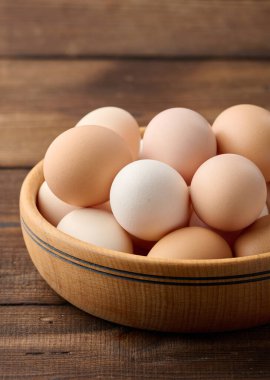 Masanın üzerinde yuvarlak bir tabakta taze kahverengi tavuk yumurtası.