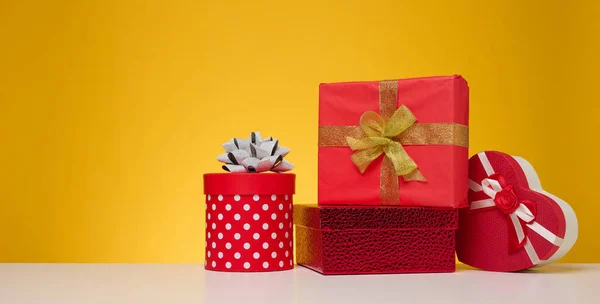 Hromada Dárkových Krabic Zabalených Barevném Papíru Žlutém Pozadí Veselé Svátky — Stock fotografie