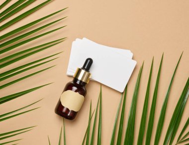 Kahverengi pipetli cam şişe kahverengi arka planda duruyor. Kozmetik, serum ve yağ konteynırı