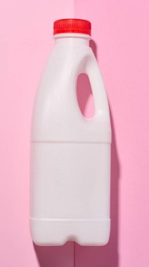 White plastic bottle for milk and dairy products on a pink background