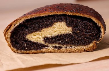 Baked roll with poppy seeds on the table, close up