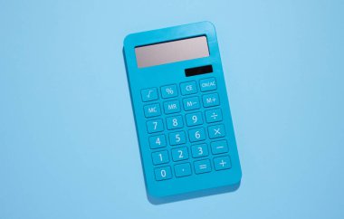 Blue plastic calculator on a blue background, top view