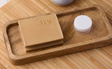 Rectangular brown laundry bar of soap on a wooden background, top view