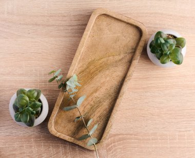 Rectangular wooden stand and eucalyptus branch on the table, background for displaying objects, top view