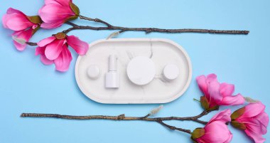 Mavi arka planda kozmetik ürünleri için kavanozlar, kaplar, reklamlar ve ürünlerin markalaşması