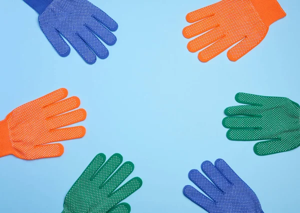 Textile work gloves on a blue background. Protective clothing for manual workers, top view