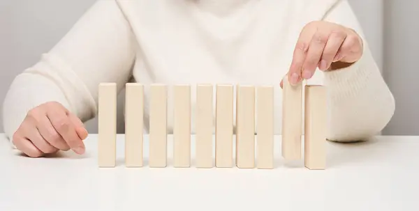 stock image Wooden blocks on the table, a woman's hand holds one. The concept of finding unique, talented employees