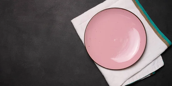 黑色桌子上的空粉红瓷盘 顶部视图 — 图库照片