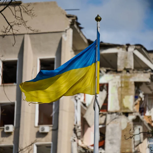 stock image Flag of Ukraine against the background of a destroyed building in Ukraine. The building was destroyed by a Russian air bomb