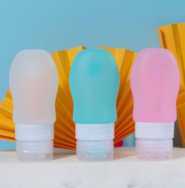 Mavi arka planda sıvı kozmetik için plastik kap