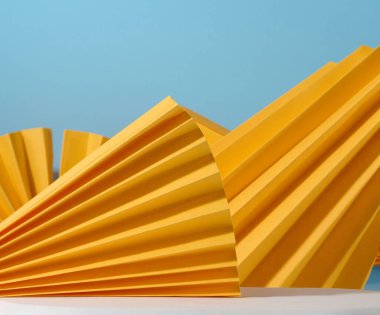 Kağıt sarısı şekilli soyut mavi arka plan ürünleri, kozmetik ürünleri göstermek için bir sahne. Reklamcılık ve tanıtım