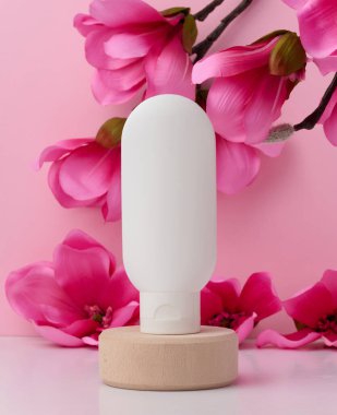 White plastic tube for liquid cosmetics on a pink background, packaging