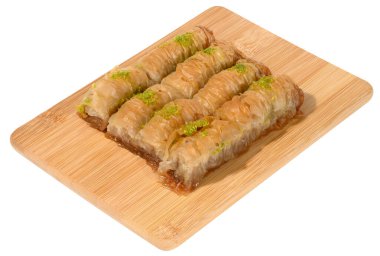 Bal içinde fırınlanmış baklava parçaları ve ahşap bir tahtanın üzerine fıstık serpiştirilmiş.