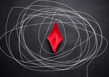 Siyah karatahta kırmızı kağıt tekne ve beyaz tebeşirle çizilmiş uzun bir yol. Zor bir yolculuk kavramı, gerçeği aramak.