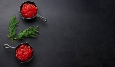 Masanın üstünde siyah bir tavada kırmızı havyar, üst manzara. Boşluğu kopyala