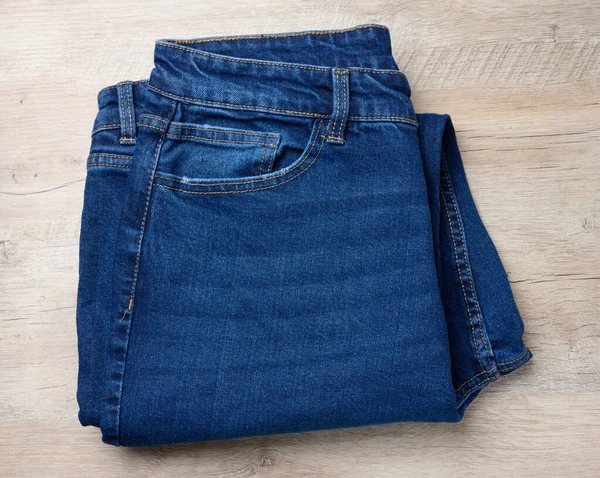Calça Jeans Azul Dobrada Fundo Madeira Vista Superior — Fotografia de Stock