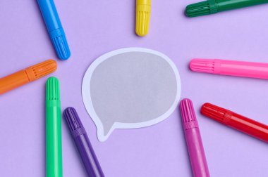 Kağıt yapıştırması ve yeşil arka planda çok renkli keçeli kalemler, üst görünüm