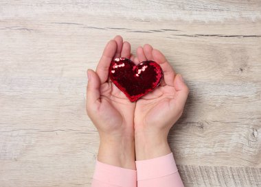 Kırmızı kalp tutan kadın elleri, bağış kavramı, nezaket.