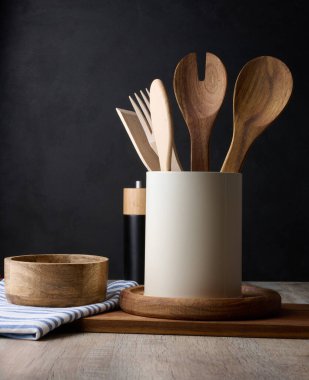 Boş kase ve tahta kaşıklar, siyah arka planda.