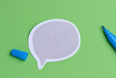 Kağıt yapıştırması ve yeşil arka planda mavi keçeli kalem, üst görünüm