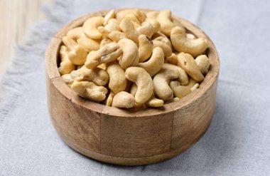 Masanın üzerinde bir ahşap kase kaju fıstığı