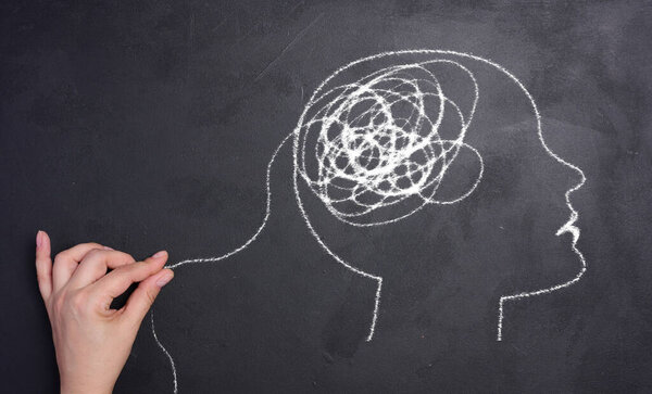 Профиль человеческой головы с запутанной спиралью в области мозга. Голова нарисована белым мелом. Концепция психического здоровья