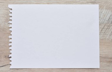 Tahta masadaki not defterinden yırtılmış beyaz bir çarşaf.