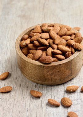 Masadaki yuvarlak ahşap tabakta soyulmuş badem çekirdekleri.